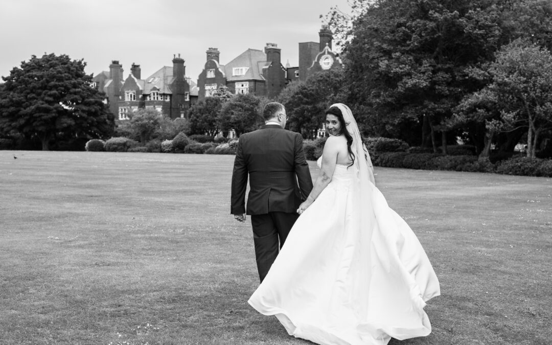 bride and groom walking across the grounds at Burlington Hotel, Folkestone
